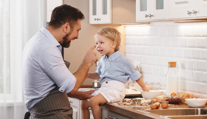 Fototapeta premium happy family in kitchen. father and child baking cookies