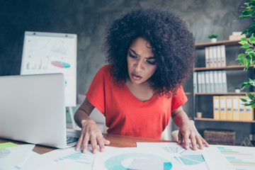 Portrait of serious worried woman expertising documents with diagrams finding mistake having bad...