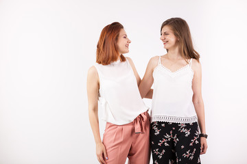 Two best female friends looking at each other and smiling