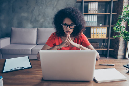 Portrait of professional thoughtful director sitting in modern comfortable office with interior looking at screen of laptop putting fingers together developing new strategy progress