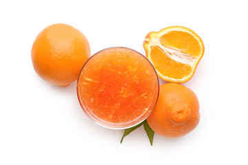 Glass with delicious citrus juice and fresh fruits on white background