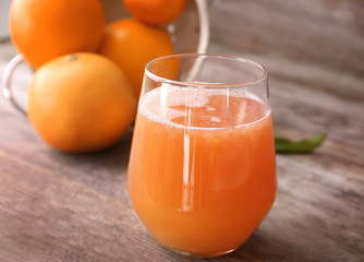 Glass with delicious citrus juice and fresh fruits on table