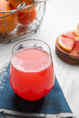Glass with delicious citrus juice on table