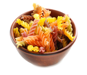 Bowl with colorful raw pasta on white background