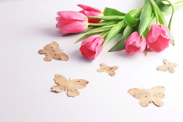 Beautiful tulips and decorative paper butterflies on white background