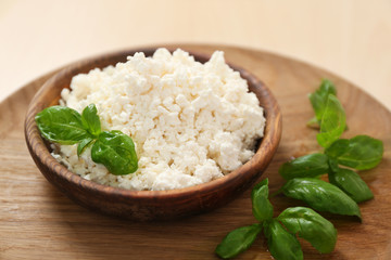 Tasty cottage cheese served with basil on plate