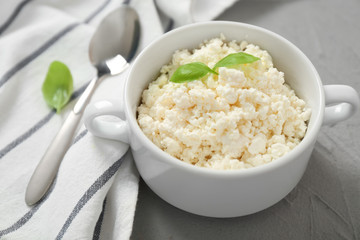 Bowl with tasty cottage cheese on table