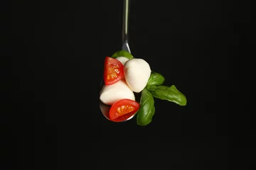 Foto op Plexiglas Spoon with mozzarella cheese balls, cherry tomato and basil on black background © Pixel-Shot