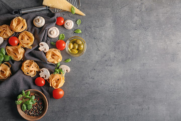 Uncooked pasta and products on grey background
