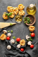 Uncooked pasta and products on grey background