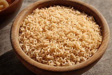 Bowl with uncooked pasta on table