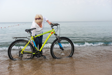 Fototapeta premium Woman in jeans standing in the water on a beach