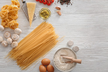 Fototapeta na wymiar Uncooked pasta and products on light background