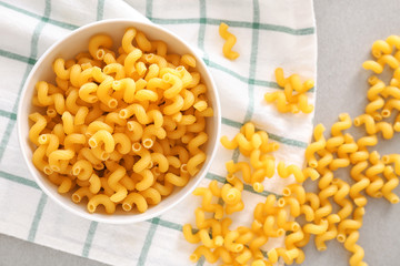 Bowl with uncooked pasta on table