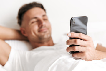 Close up of smiling man using mobile phone