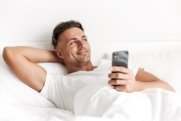 Smiling man holding mobile phone