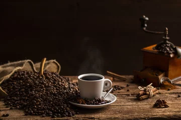 Foto op Plexiglas Kopje koffie met koffiebonen en molen op houten tafel © aitormmfoto