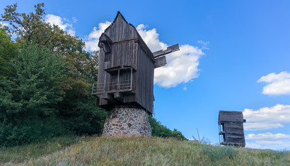 Two old historic wooden windmills on a hill top