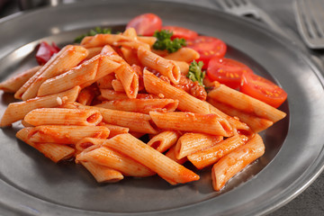 Tasty pasta with tomato sauce on plate, closeup