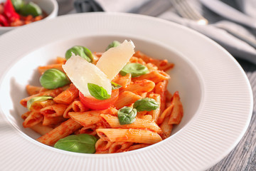 Plate of delicious pasta with tomato sauce on table, closeup