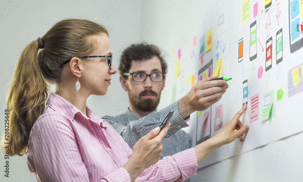 Poster two creative web designers are developing mobile applications in the workplace.
