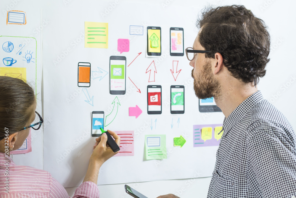 Poster two creative web designers are developing mobile applications in the workplace.