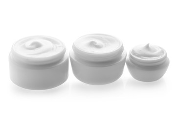 Jars with skin care cosmetics on white background