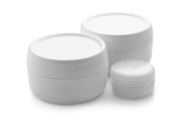 Jars with skin care cosmetics on white background