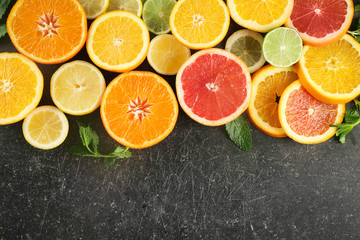 Flat lay composition with ripe citrus fruits on dark background