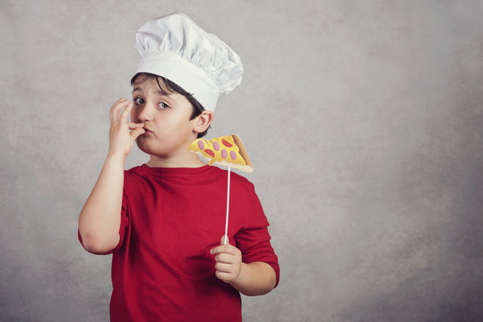 niño cocinero gracioso con un trozo pizza 