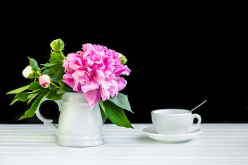 Obraz na płótnie Canvas A cup of tea and peonies