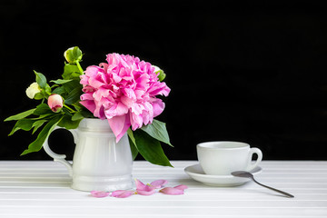A cup of tea and peonies