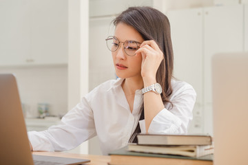Beautiful asian business woman working with laptop in white cafe background.