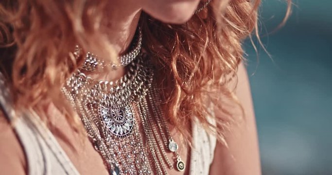 Young boho woman with jewelry relaxing at the beach