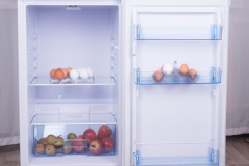 Open fridge, eggs, pears and apples on the shelf of refrigerator, healthy nutrition concept