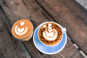 Cup of hot cappucino is on the wooden table