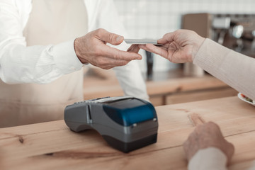 Paying the check. Focused photo on electronic device that lying on the table and being ready for receiving payment