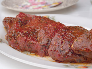 Rohes mariniertes Rindersteak auf Teller