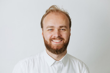 Close up portrait of happy smiling young bearded man looking at camera. Bearded hipster man