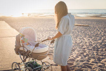 Woman pushing stroller outdoors. © abelena