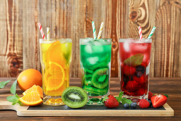 Three glasses of different cold summer drinks or refreshing cocktails yellow, green, red in toxic colors.