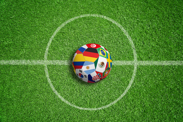 Fußballrasen mit Fußball und Teamflaggen