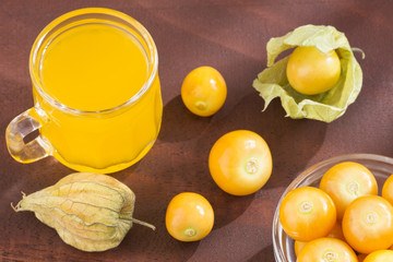 Uchuva juice. Wooden background - Physalis peruviana