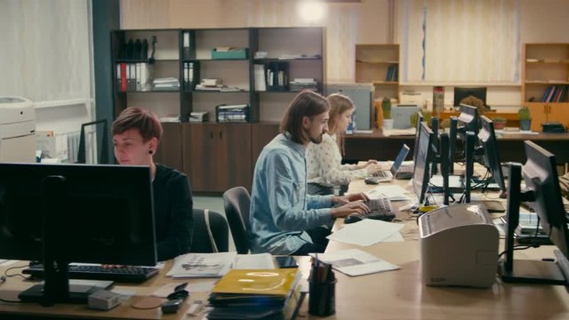 Young Employees are Working Together at their Computers in the Office of Real Company