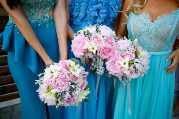 Bridesmaids in blue dress holding bouquet of flowers
