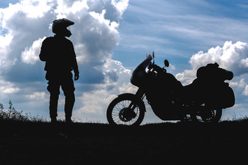 Biker man and tourist off road motorcycle with side bags Young man rider to rest during the trip to...