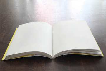 open book with empty pages on a wooden table with copy space