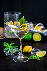 Cool transparent cocktail with olives on black background