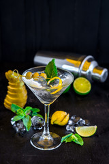 Cool transparent cocktail with olives on black background