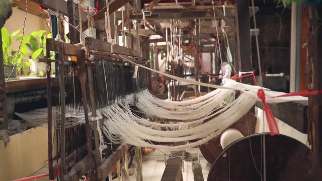 Abandoned foot-treadle loom machine with threads. Shot with Sony a7s and Atomos Ninja Flame in Indonesia